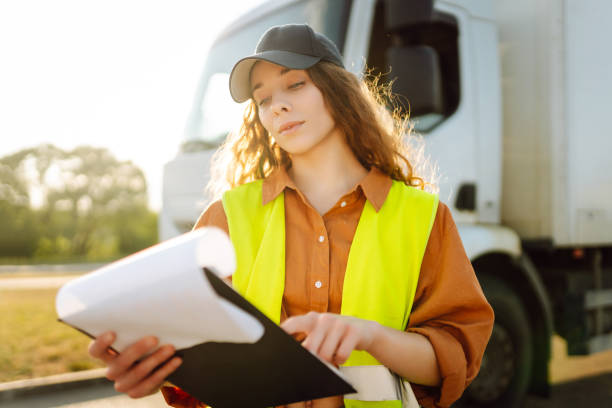 istock Young woman professional driver checking shipment list on a -parking lot. 2149413514
