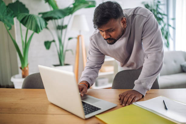 istock Young indian man working on laptop at home 2149415227