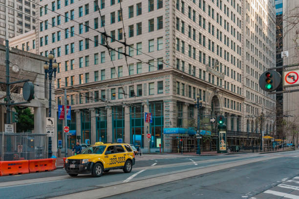 San Francisco, California, April 8, 2024. Yellow taxi cab drives through an intersection in downtown San Francisco.