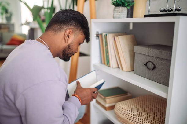 istock Young indian man reading at home 2149416481