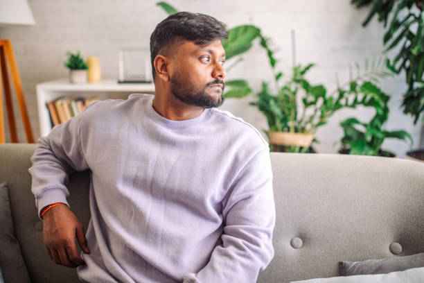 istock Young indian man relaxing on couch at home 2149416806