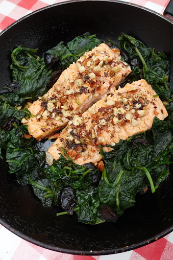 Trout with almonds cooked with spinach cooked in water and browned during cooking