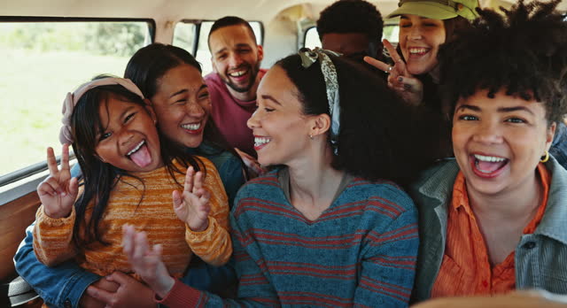 Travel, selfie and friends in a van with kid, music and hand rocker sign while bonding on a backseat together. Freedom, radio and excited girl child with group of people in a camper for adventure