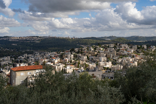 In this landscape of the Judea mountains, Israel, one can see the muslim village Abu Ghosh, behind it the Jewish town Mevasseret Zion, and Jerusalem in the horizon.