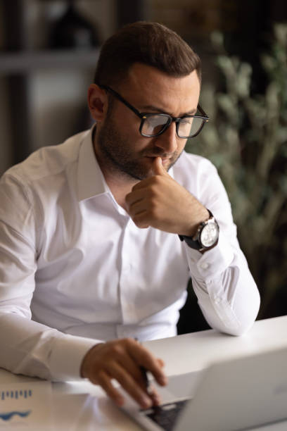 istock Serious freelancer man in stylish glasses working at laptop 2149419926