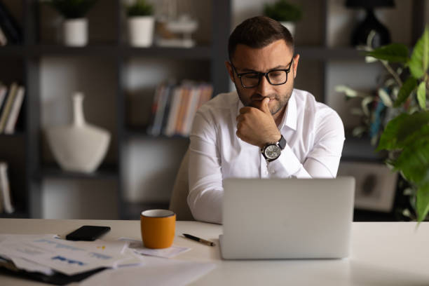 istock Serious freelancer man in stylish glasses working at laptop 2149420088