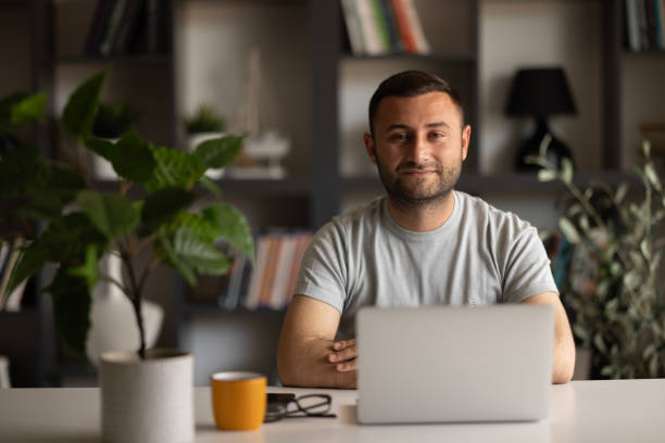Free Stock Photo of A man sitting at a desk with a laptop in front of ...