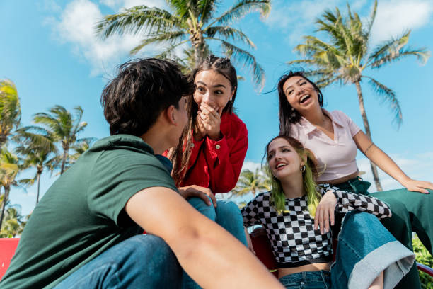 Friends talking sitting on bench at public park