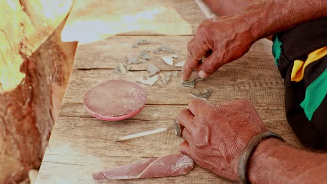 4K video: men's hands making dolphin figurines for sale, Indonesia