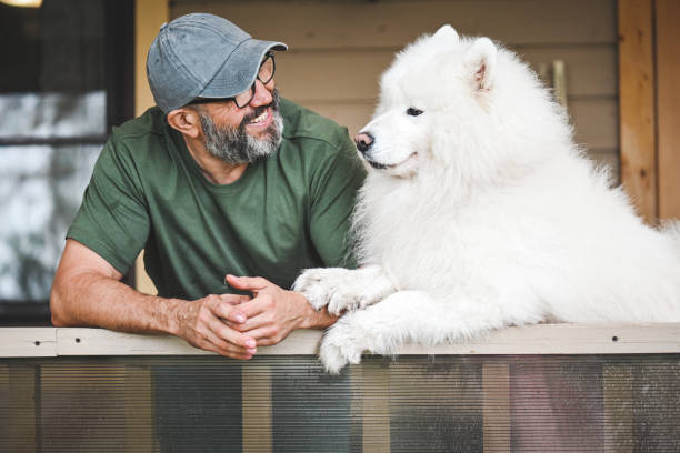 istock mature adult man with samoyed dog 2149424076