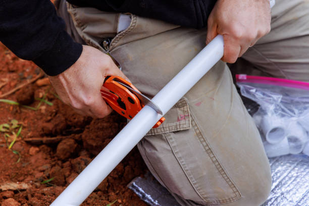 Technician plumber uses special scissors to cut plastic PVC pipe during repair work
