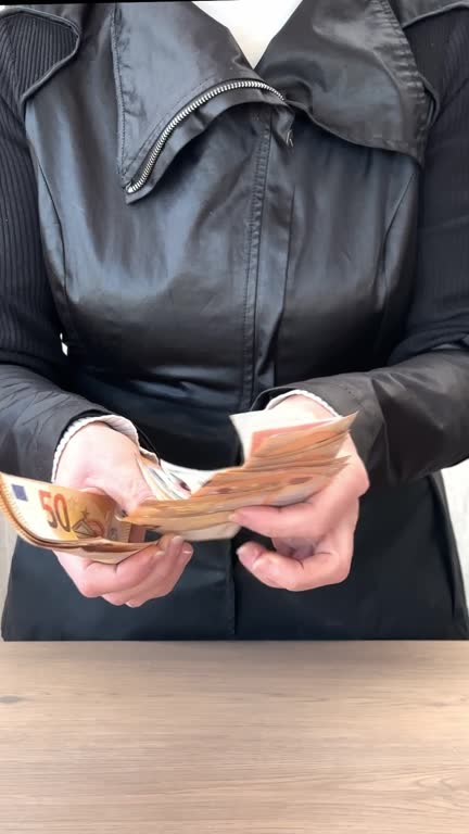 The hands of a woman in business clothes count a stack of paper euro banknotes, time lapse. Successful commercial transaction, cost control, debt repayment, lending, borrowing money, corruption, bribe