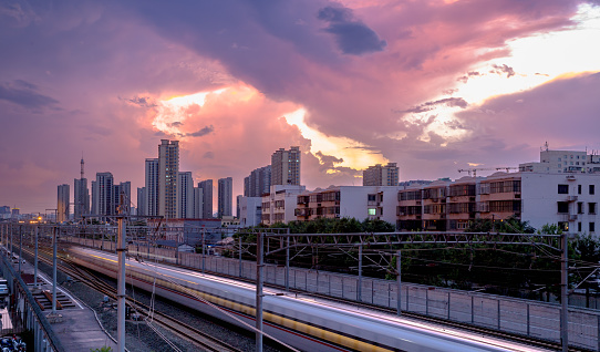 the train passing the city with dramatic clouds in the background