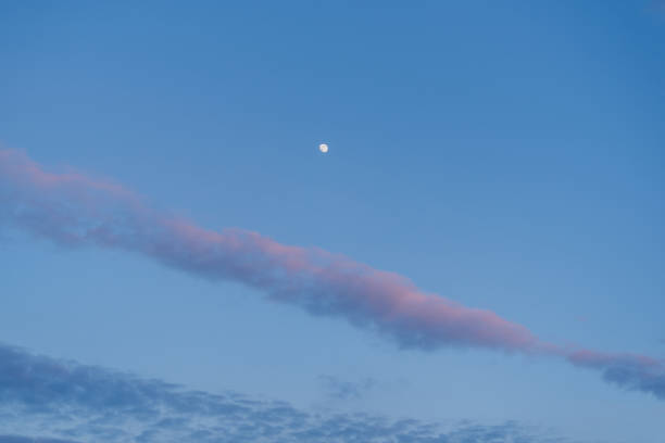 Moon and blue sky with few clouds during the sunset at speing