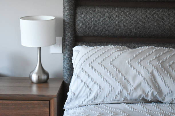 istock Nightstand next to the bed with lamp 2149431467