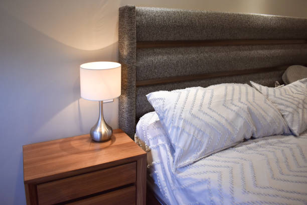 istock Nightstand next to the bed with lamp 2149432037