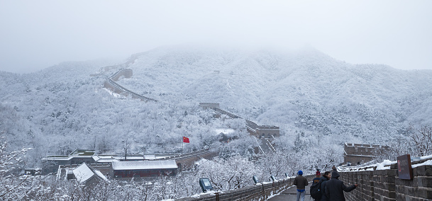 Beijing, China—Dec 2021:the Badaling Great Wall with snow covered forest and fog in winte