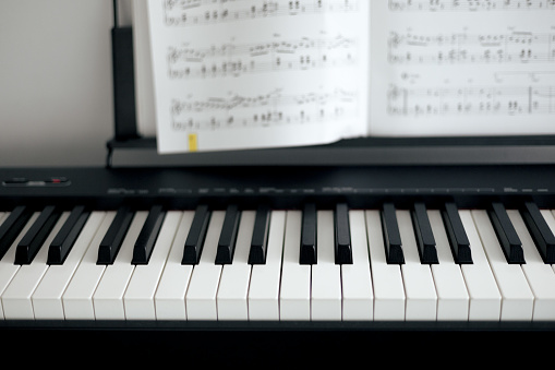 electronic piano keys and music sheets, black and white colors.