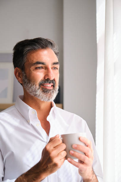 istock A man in a white shirt is holding a coffee cup and smiling. 2149435048