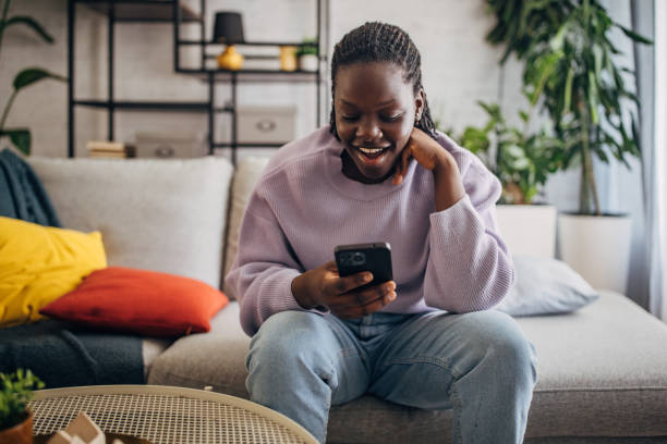 istock Joyful woman using smartphone at home 2149435325