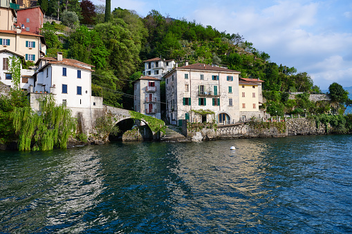Very old bridge and residential homes in Nesso, a small village on the Lake Como shore. Province of Como. Lombardy. Italy.
