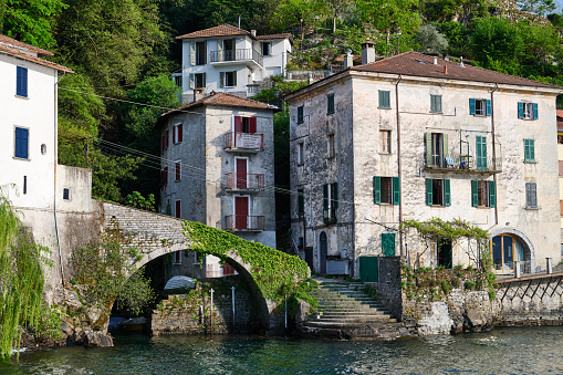 Very old bridge and residential homes in Nesso, a small village on the Lake Como shore. Province of Como. Lombardy. Italy.