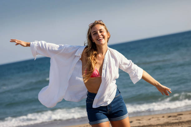 istock Beautiful young woman enjoying freedom while having fun at the beach 2149437805