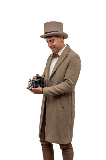 the early 20th century vintage photographer clad in a bowler hat and trench coat, capturing a moment with an antique camera, transporting you to an era where photography was an art white background