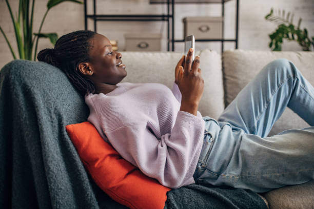 istock Young woman relaxing on sofa with digital tablet 2149439810
