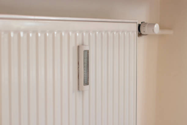 istock Adjusting the radiator temperature using a thermostat in an apartment with central heating 2149440017