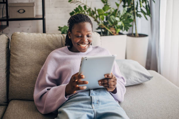 istock Young woman relaxing on sofa with digital tablet 2149440194