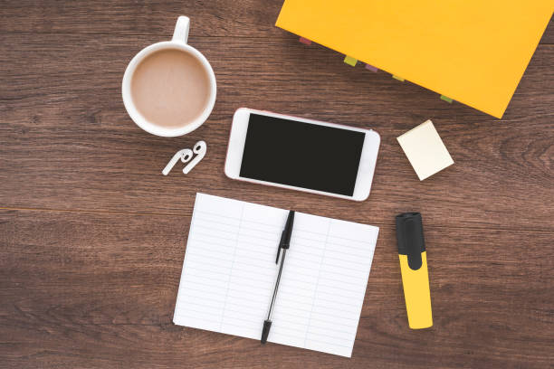 smartphone, wireless headphones, a textbook and a notebook for writing foreign words on a wooden table, the concept of study, place for text