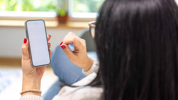 istock Woman holding mobile phone with blank desktop white screen 2149442903