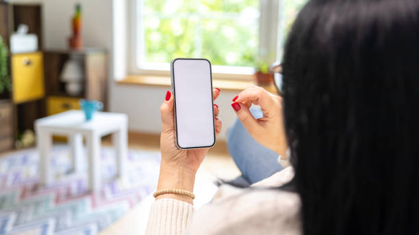 istock Woman holding mobile phone with blank desktop white screen 2149442919