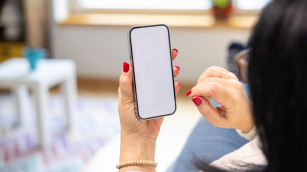 istock Woman holding mobile phone with blank desktop white screen 2149442920