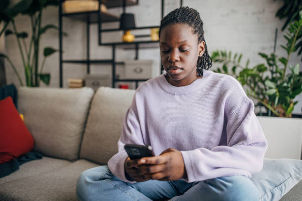 istock Young woman relaxing with smartphone at home 2149443893