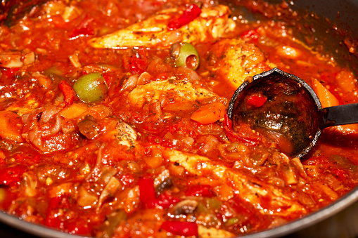 Homemade Organic Chicken Cacciatore in pan with ladle.