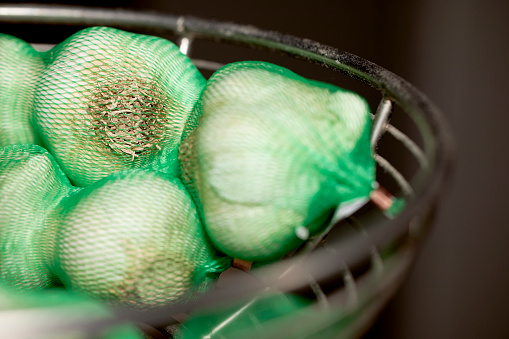 Close up of Garlic bulbs in a green net bag