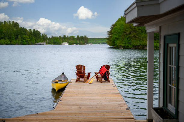 istock Two Adirondack chairs and yellow canoe on a dock 2149445938
