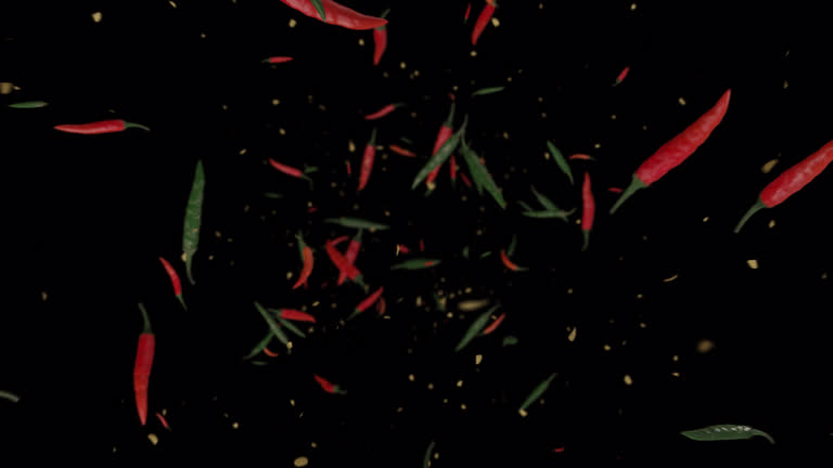 Red and green chili exploding to the camera in slow motion.