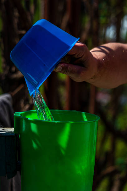 Mid-adult man refilling his reusable water bottle on the drinking fountain in Yerevan in Armenia. Close-up.