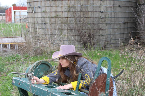 Girl in hat working on farm smiling at camera.