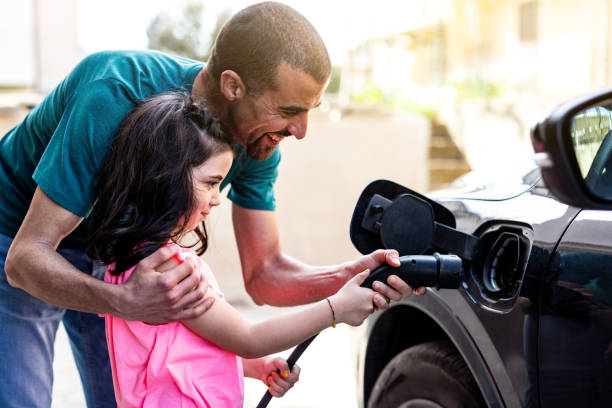 istock Man and girl charging ev car at home 2149453751
