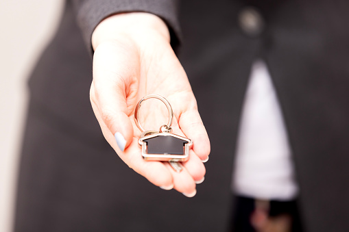 Close-up of a woman's hands holding the keys to a new house