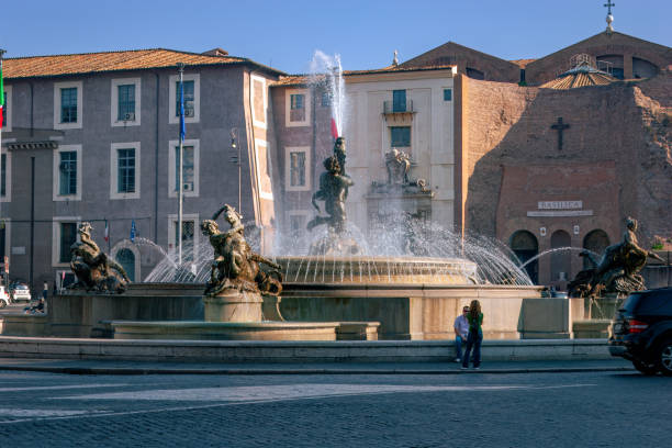 Rome, Italy - October 11, 2007: The Piazza della Republica viewed from Via Nazionale. In the middle of the square is the Fountain of the Naiads. In the background is a section of the Baths of Diocletian. The tepidarium was converted to become the Basilica of Santa Maria degli Angeli e dei Martiri. The architect was the famous sculptor and artist Michelangelo. Photo shot in the late afternoon sunlight; horizontal format.