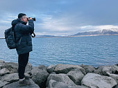 portrait solo travel asian chinese man photographing at seaside
