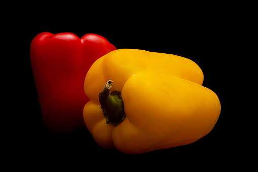 Tasty red and yellow pepper in black background
