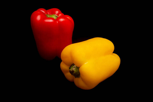 Tasty red and yellow pepper in black background