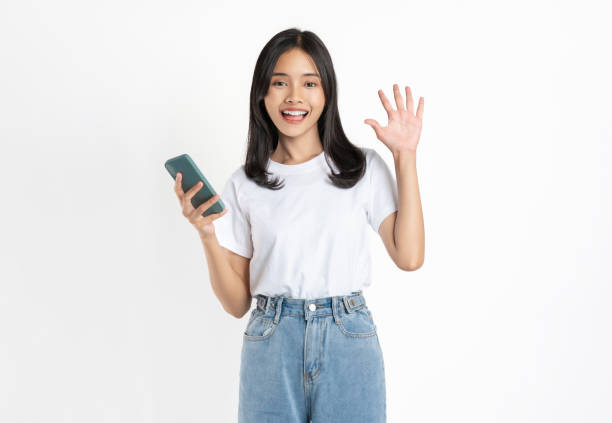 istock Smiling student girl in university uniform holding smartphone and looking on white background. 2149460180