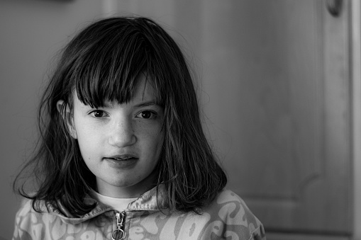 Black and white portrait of autistic girl in lower teenage.